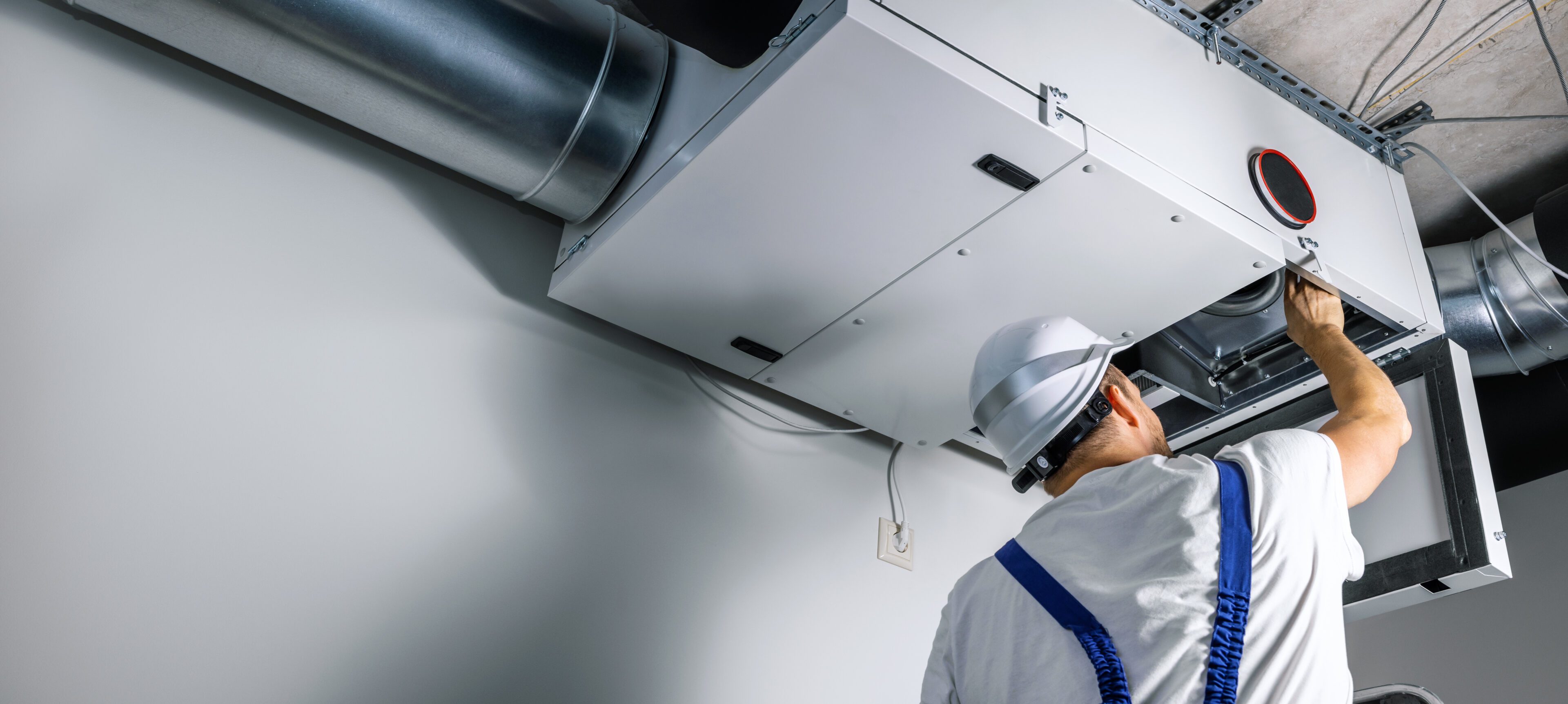 Technician inspecting large air ventilation system.