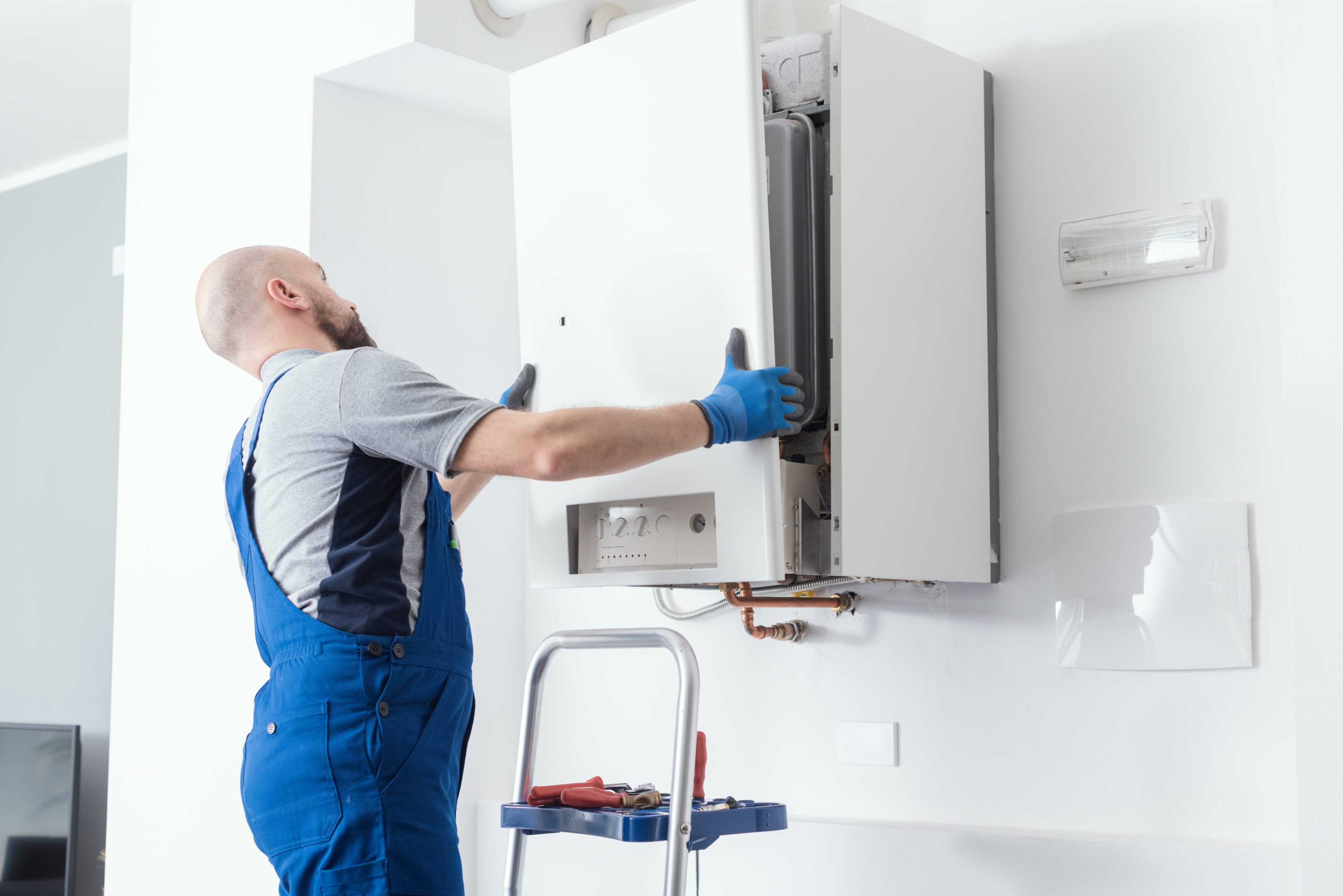 Technician installing a wall-mounted heating unit.