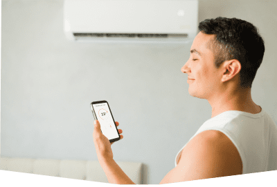 Man adjusting air conditioner with smartphone app.